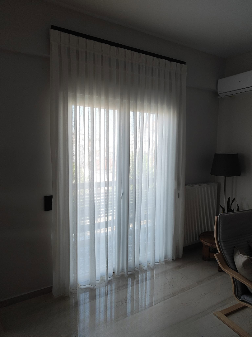 Λευκή διάφανη κουρτίνα με ντραπέ σε μπαλκονόπορτα