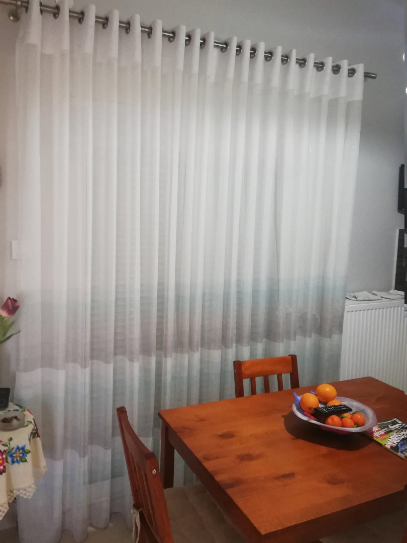 Λευκή διάφανη κουρτίνα με κρίκους σε τραπεζαρία